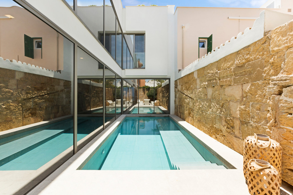 Modelo de piscina alargada mediterránea pequeña rectangular en patio lateral