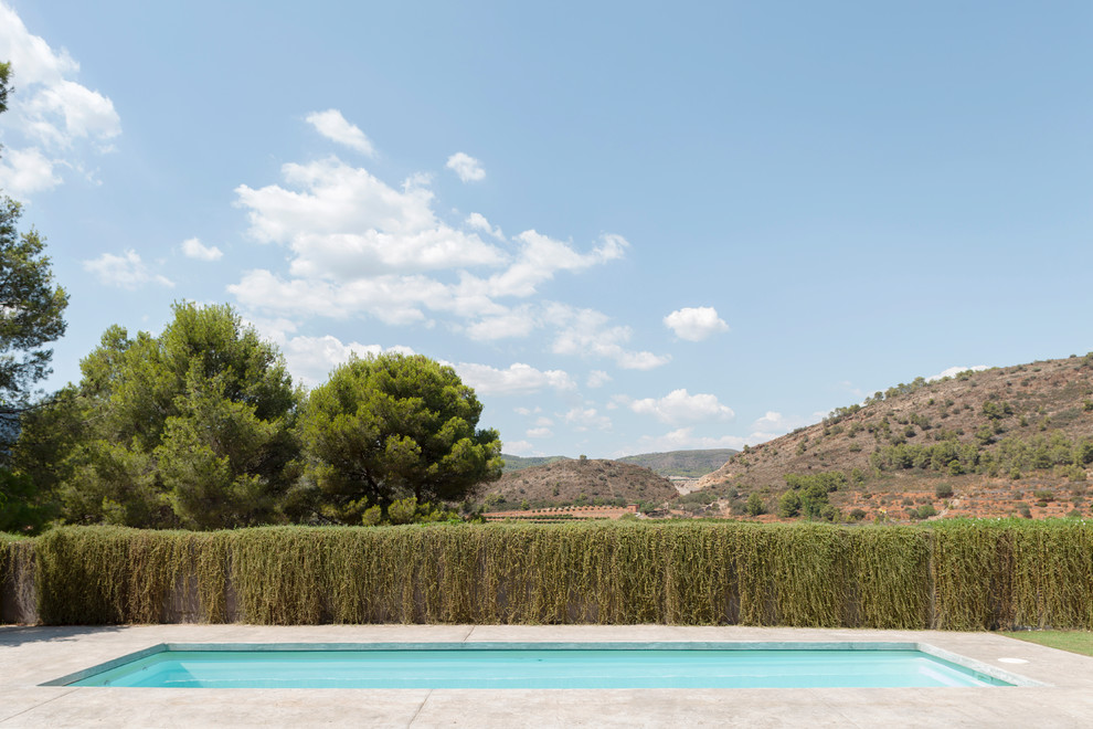 Стильный дизайн: прямоугольный бассейн в средиземноморском стиле с покрытием из бетонных плит - последний тренд