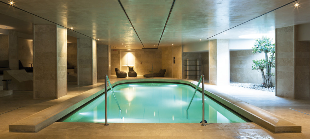 Aménagement d'une très grande piscine intérieure naturelle contemporaine sur mesure avec un bain bouillonnant.