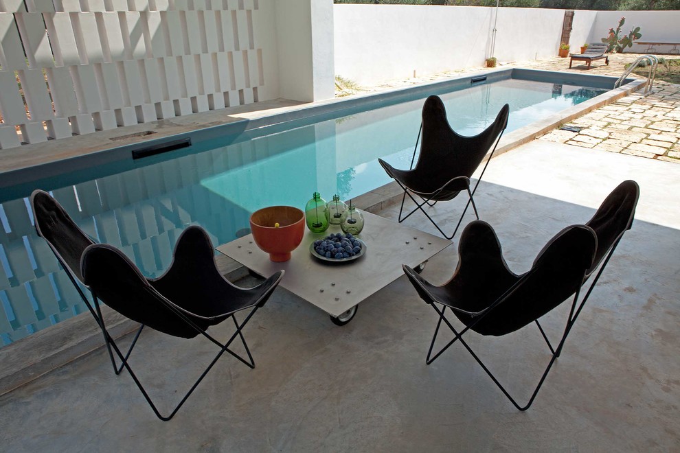 На фото: прямоугольный бассейн среднего размера на заднем дворе в стиле кантри с покрытием из каменной брусчатки с