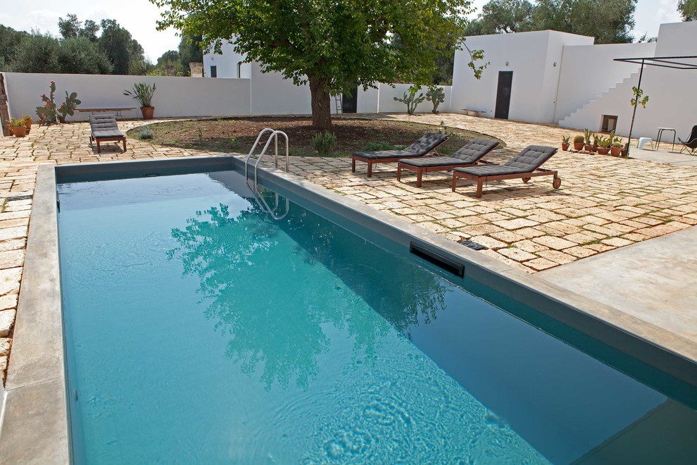 Идея дизайна: прямоугольный бассейн среднего размера на заднем дворе в стиле кантри с покрытием из каменной брусчатки