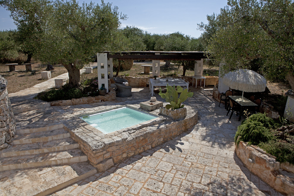Foto de piscina campestre pequeña rectangular en patio delantero con adoquines de piedra natural
