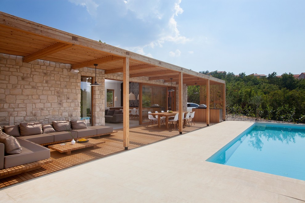 Foto de piscina infinita nórdica grande rectangular en patio con adoquines de hormigón