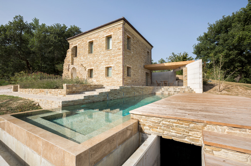 Landhausstil Infinity-Pool hinter dem Haus in rechteckiger Form mit Dielen in Sonstige