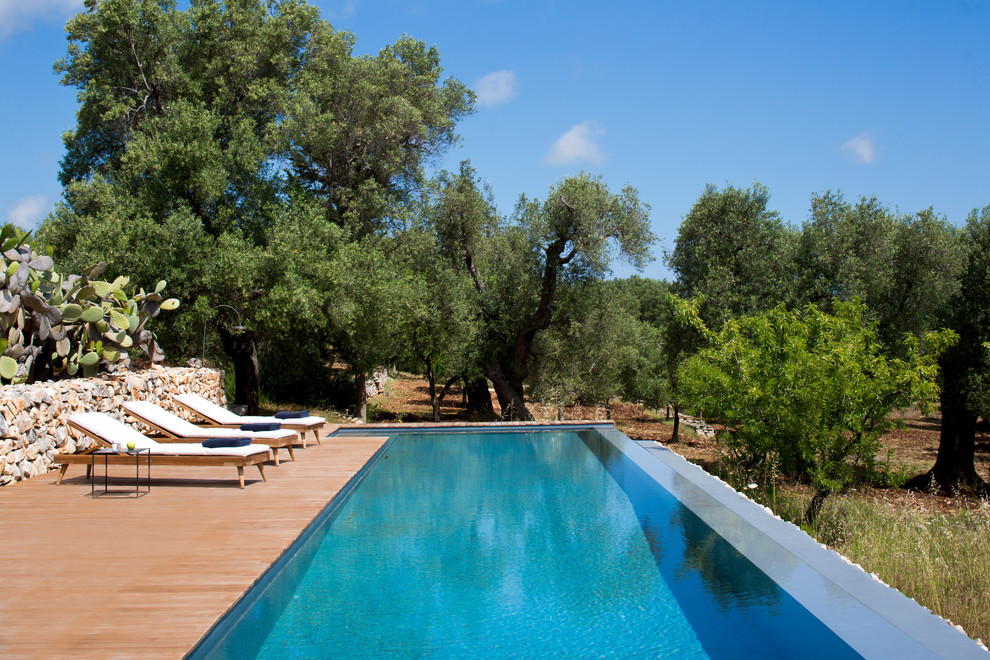 Ispirazione per una piscina a sfioro infinito mediterranea rettangolare dietro casa