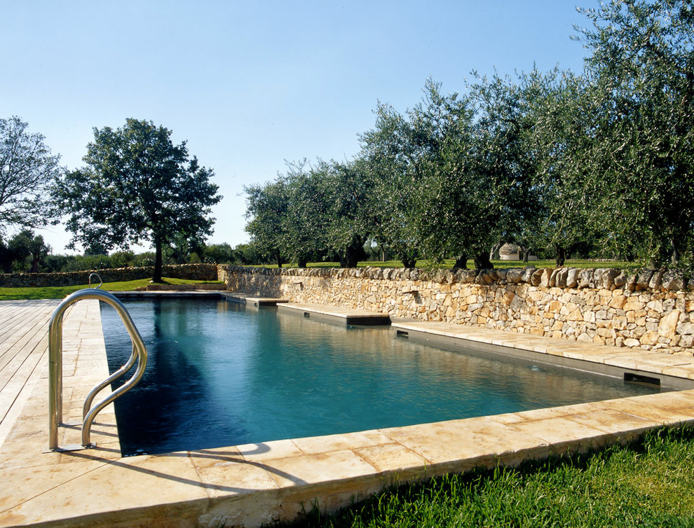 Foto på en mellanstor lantlig baddamm på baksidan av huset, med en fontän och naturstensplattor