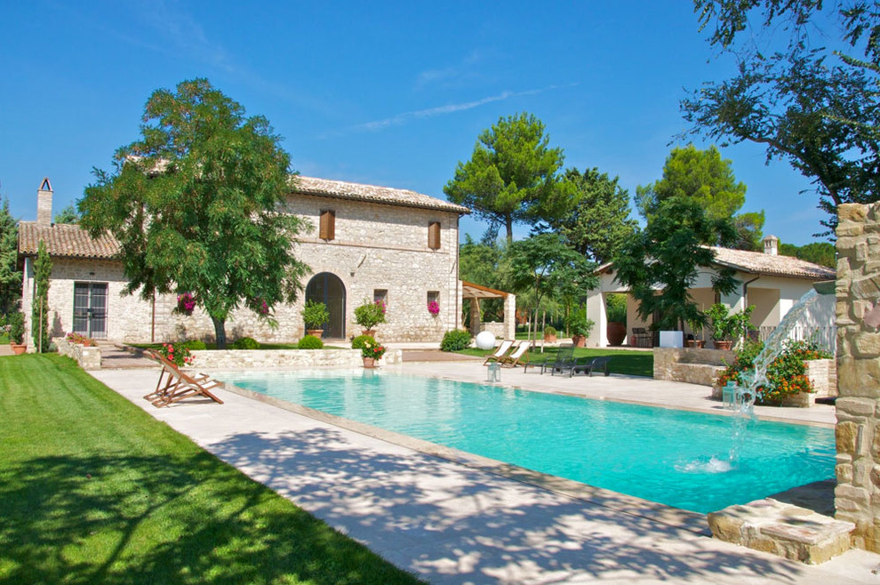 Esempio di una piscina country rettangolare di medie dimensioni e nel cortile laterale con pavimentazioni in pietra naturale