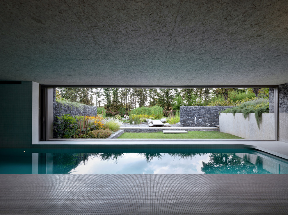 На фото: прямоугольный бассейн в доме в стиле модернизм с покрытием из плитки с