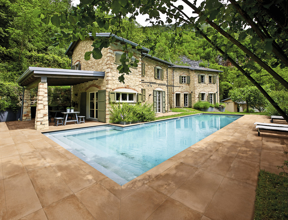 Foto de casa de la piscina y piscina alargada mediterránea grande en forma de L en patio lateral con suelo de baldosas