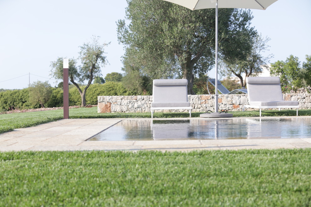 Mittelgroßer Landhaus Infinity-Pool hinter dem Haus in rechteckiger Form mit Natursteinplatten in Bari