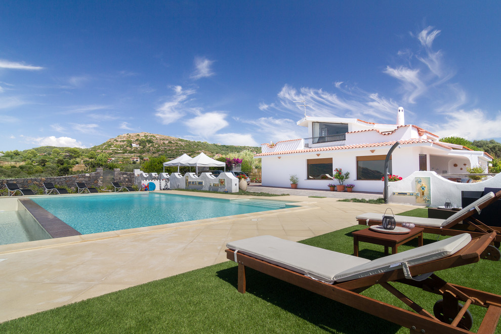 Idée de décoration pour une grande piscine latérale méditerranéenne rectangle avec des pavés en pierre naturelle.