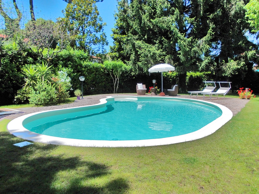 На фото: естественный бассейн среднего размера, произвольной формы на внутреннем дворе в современном стиле с домиком у бассейна и мощением клинкерной брусчаткой