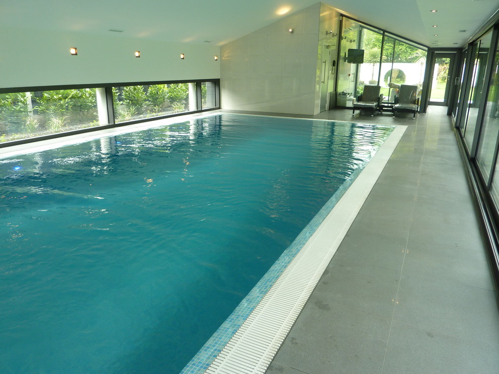 Immagine di una piscina minimalista di medie dimensioni con piastrelle