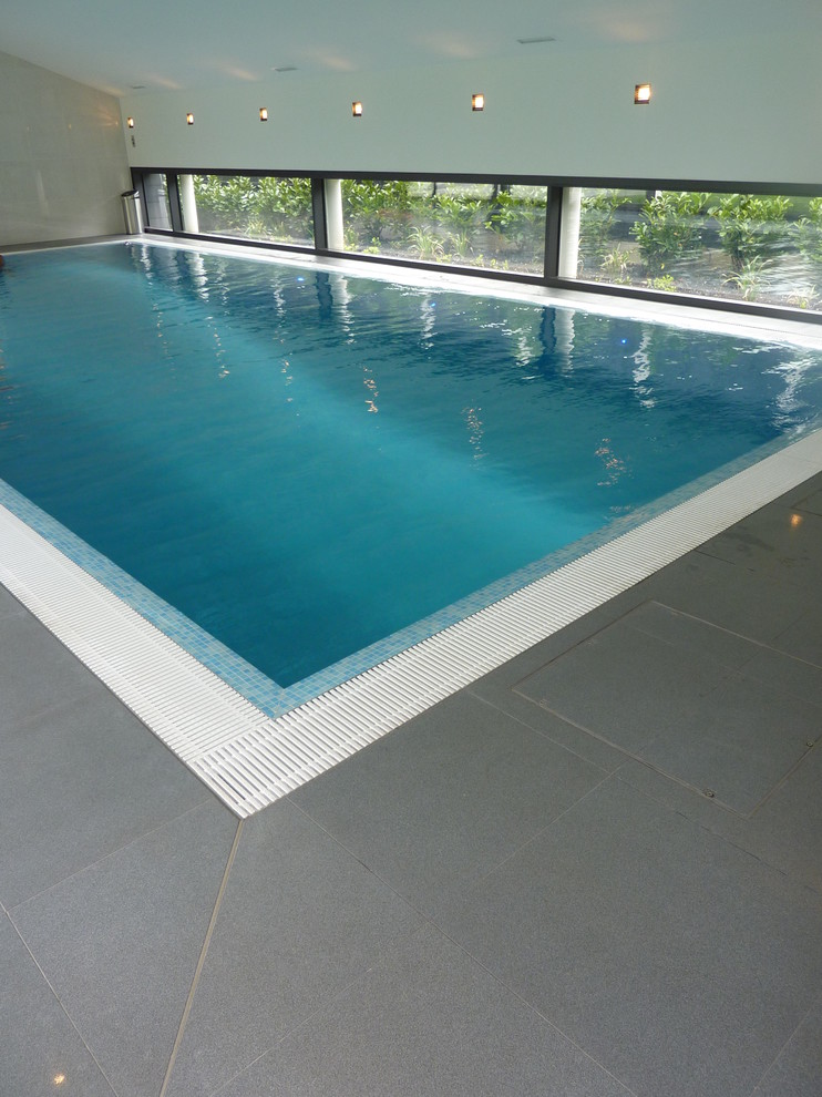 Immagine di una piscina minimalista di medie dimensioni con piastrelle