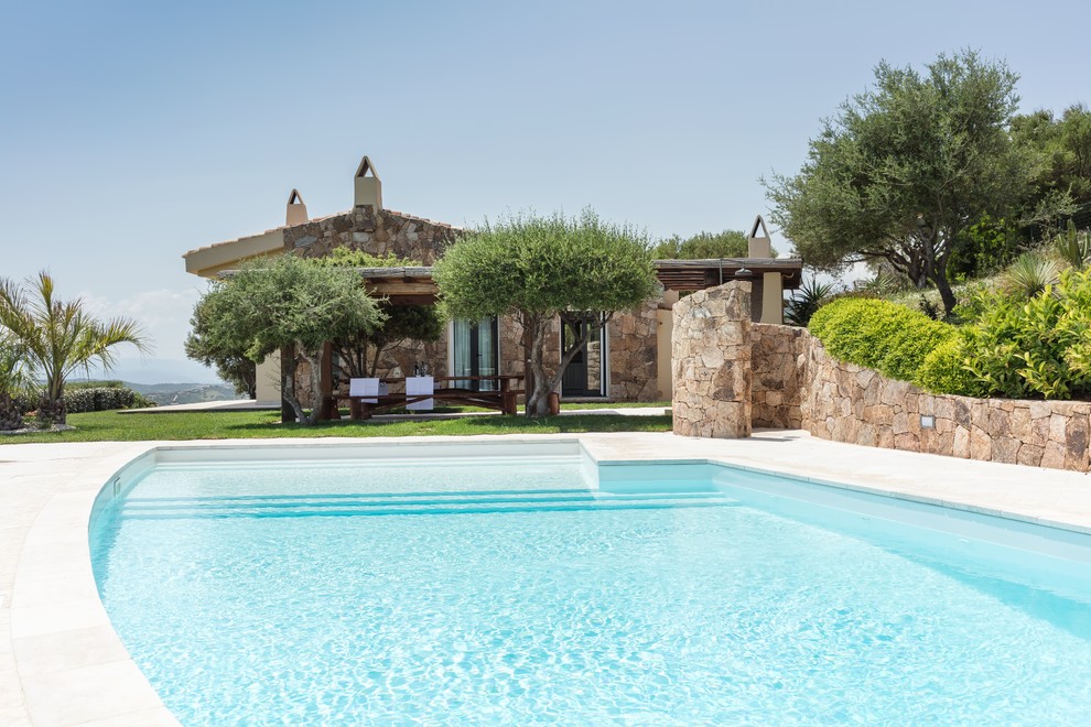 Идея дизайна: бассейн произвольной формы на заднем дворе в средиземноморском стиле с покрытием из плитки