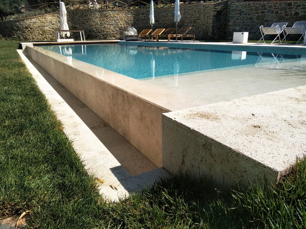 Imagen de piscinas y jacuzzis infinitos contemporáneos grandes rectangulares en patio trasero con adoquines de piedra natural