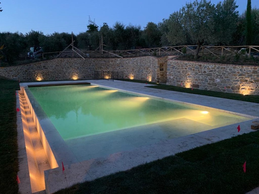 Foto de piscinas y jacuzzis infinitos actuales grandes rectangulares en patio trasero con adoquines de piedra natural