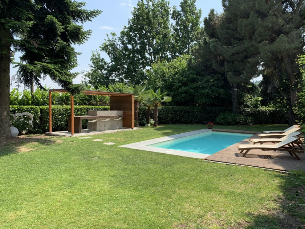 Idee per una grande piscina rettangolare davanti casa con pavimentazioni in pietra naturale