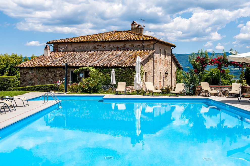 Esempio di una piscina country personalizzata dietro casa con piastrelle
