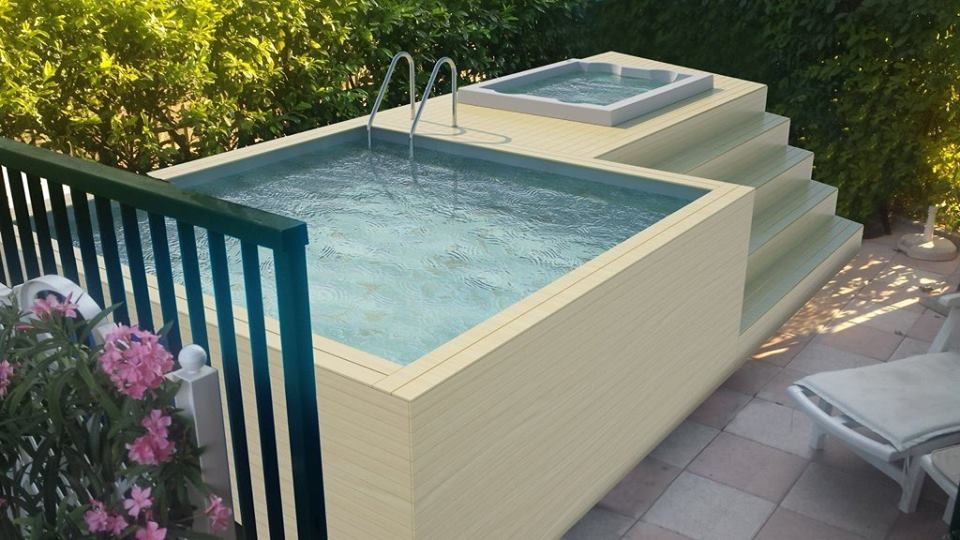Idée de décoration pour une piscine hors-sol et avant design de taille moyenne et rectangle avec un bain bouillonnant et une terrasse en bois.