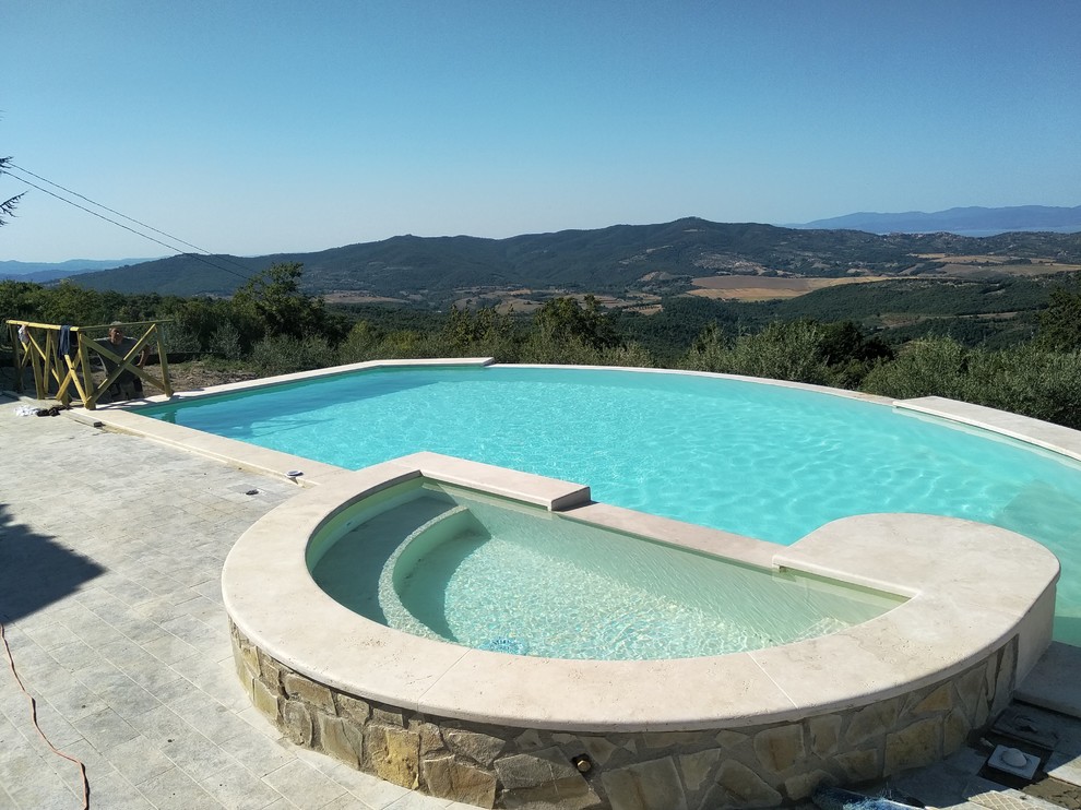 Idee per una piscina a sfioro infinito minimal personalizzata di medie dimensioni e dietro casa con una vasca idromassaggio e pavimentazioni in pietra naturale