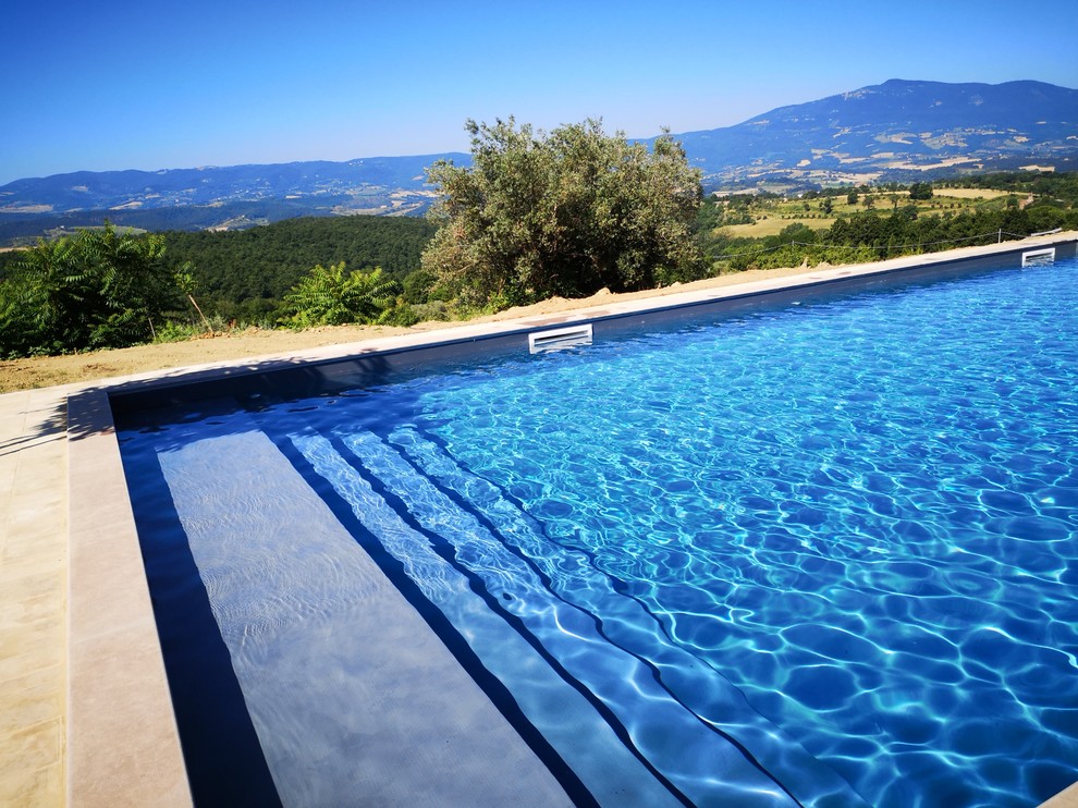 Esempio di una piscina country rettangolare di medie dimensioni e davanti casa con una dépendance a bordo piscina e pavimentazioni in mattoni
