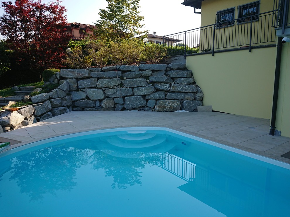 Esempio di una piscina mediterranea personalizzata di medie dimensioni e nel cortile laterale con piastrelle