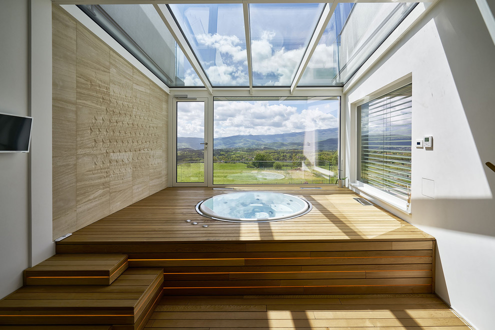 Idées déco pour une piscine contemporaine ronde avec un bain bouillonnant, une cour et une terrasse en bois.