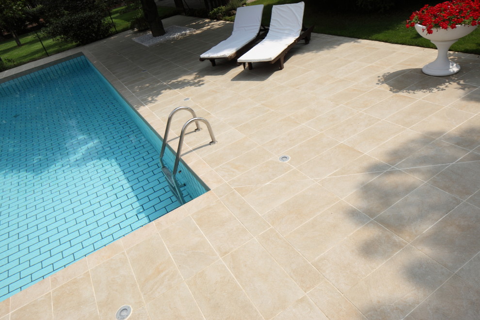 Idee per una grande piscina minimalista rettangolare nel cortile laterale con piastrelle