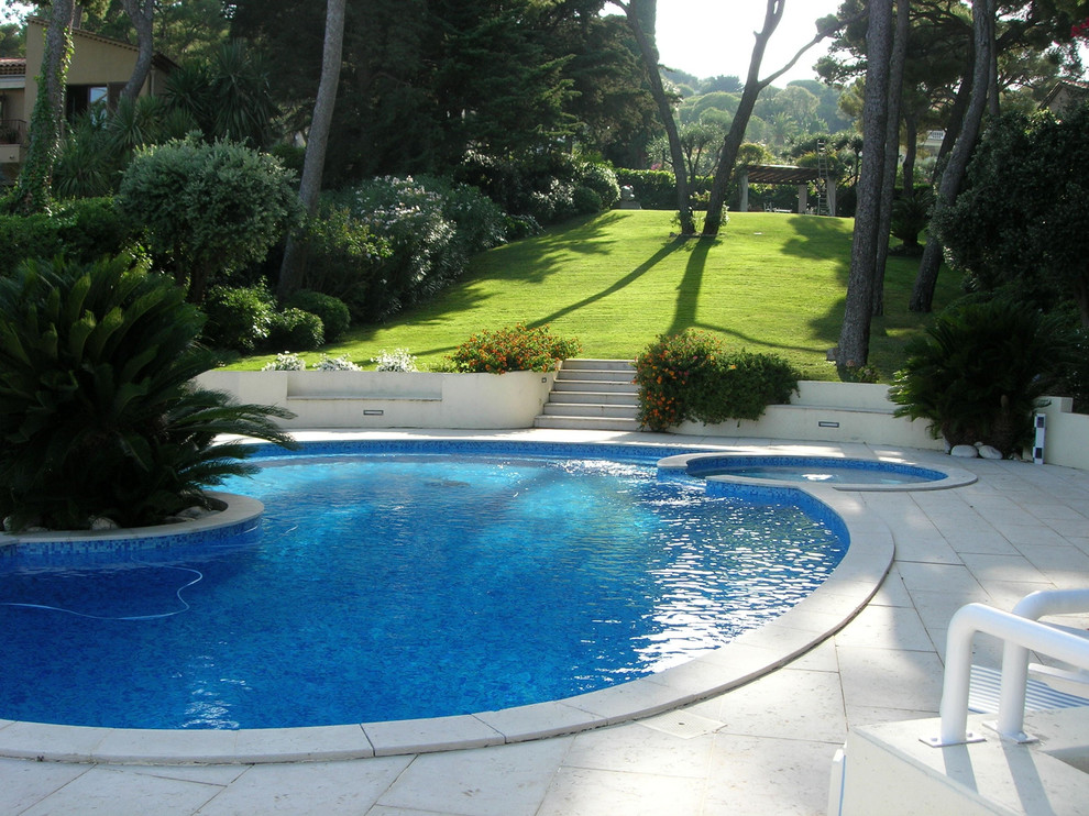 Ispirazione per una piccola piscina design rotonda nel cortile laterale con una vasca idromassaggio e piastrelle