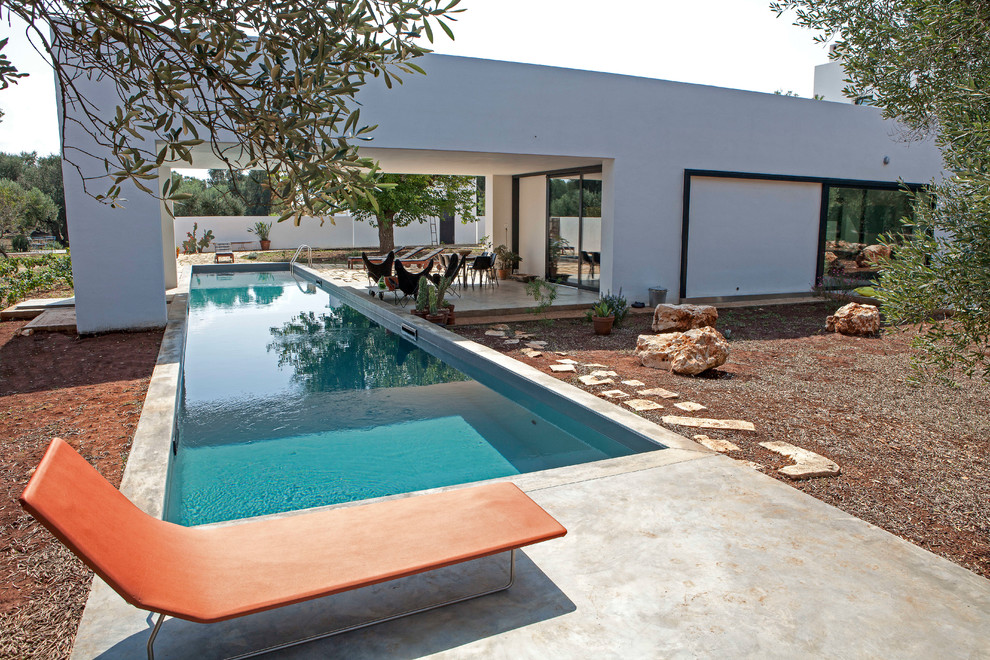 Ispirazione per una piscina monocorsia design personalizzata di medie dimensioni e davanti casa con una dépendance a bordo piscina e pavimentazioni in cemento