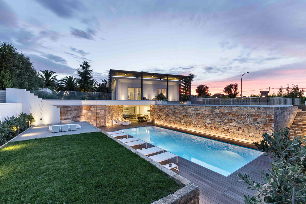 Diseño de casa de la piscina y piscina alargada contemporánea de tamaño medio rectangular en patio trasero con entablado