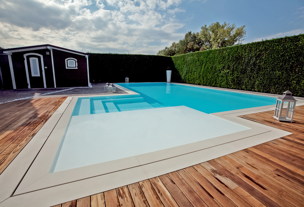 Foto di una grande piscina design personalizzata dietro casa con una dépendance a bordo piscina e pedane