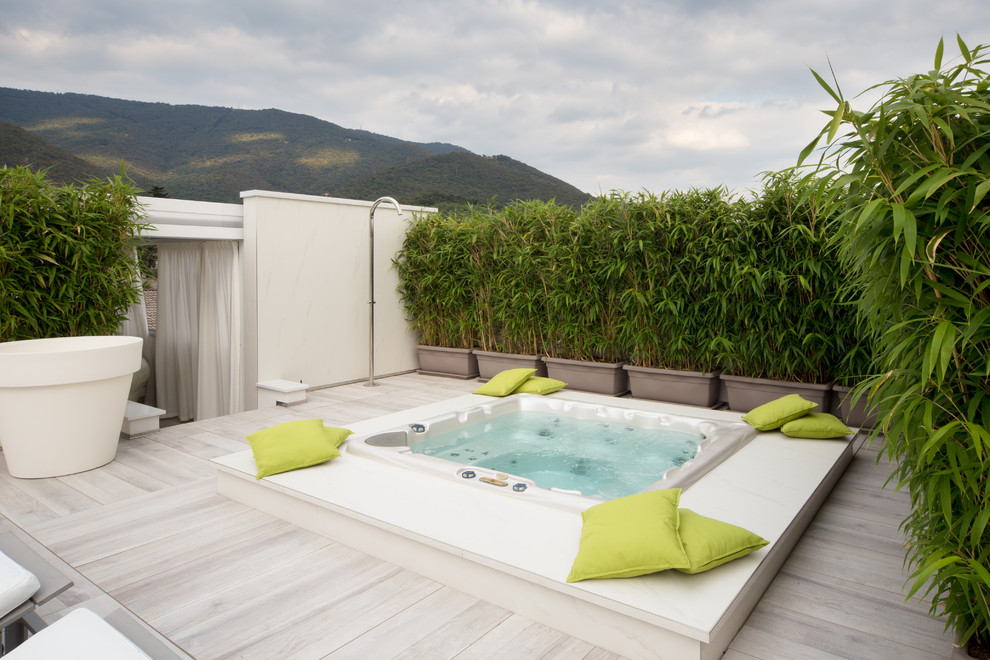 Idées déco pour une piscine contemporaine de taille moyenne avec un bain bouillonnant et une terrasse en bois.