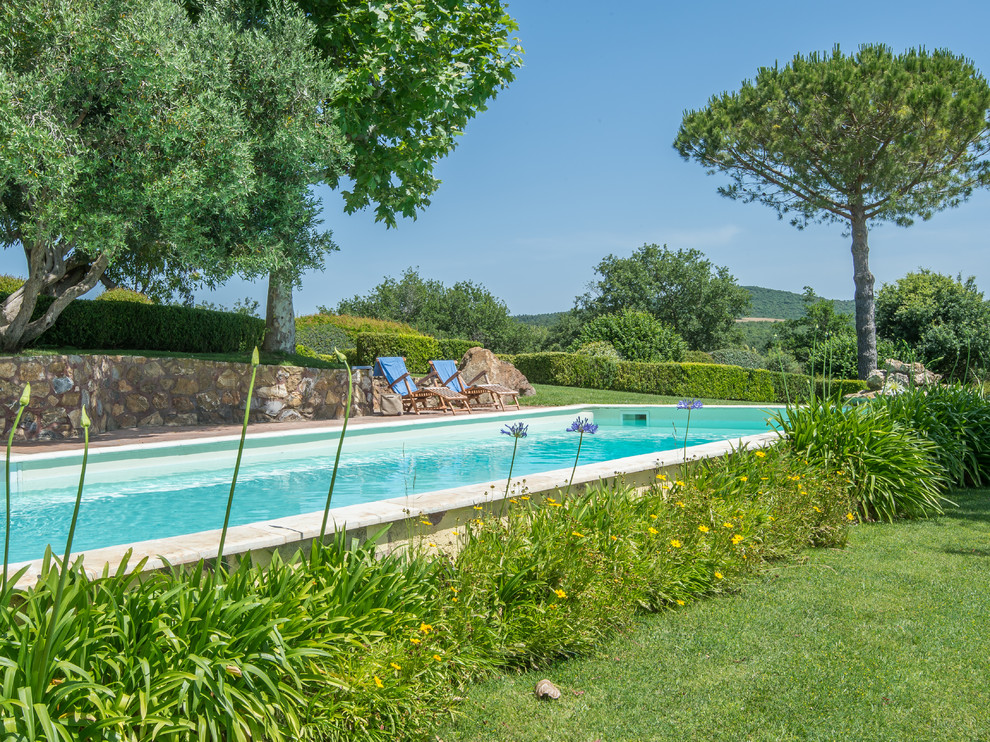 Foto de piscina de estilo de casa de campo grande rectangular con adoquines de piedra natural