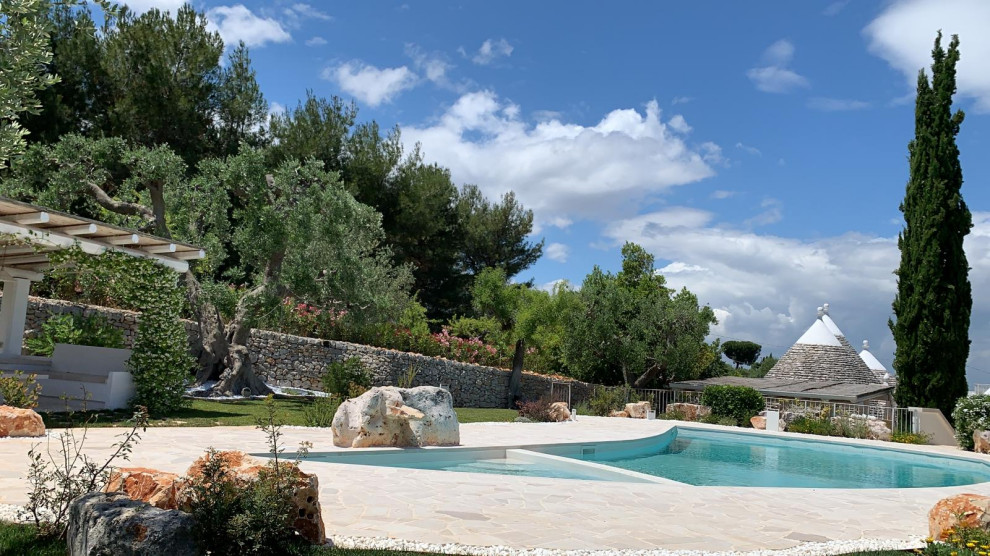 Foto di una piscina mediterranea personalizzata dietro casa con pavimentazioni in pietra naturale