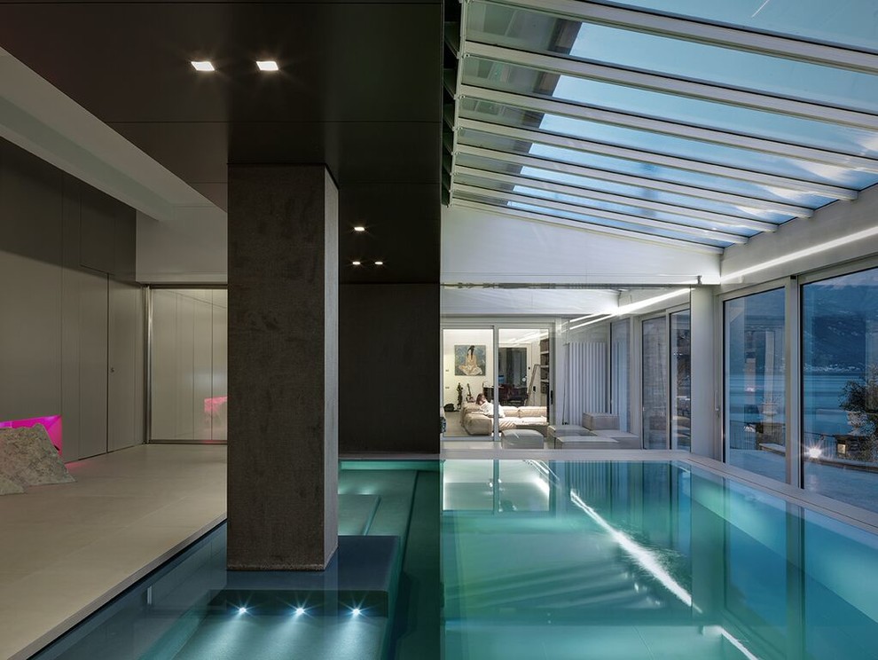 Large trendy indoor pool photo in Milan