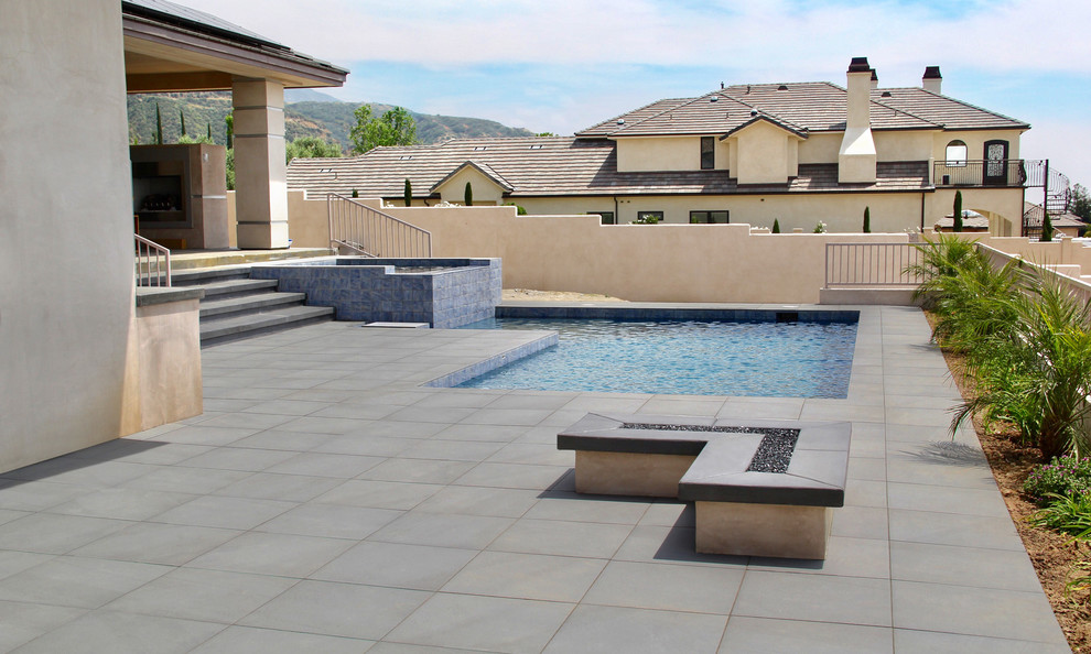 Contemporary courtyard l-shaped swimming pool in Orange County with tiled flooring.