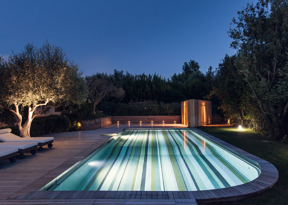 На фото: бассейн произвольной формы, среднего размера на заднем дворе в современном стиле с настилом с
