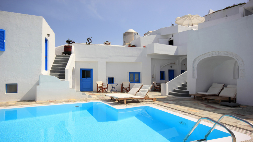 Ejemplo de piscina mediterránea en patio con adoquines de piedra natural