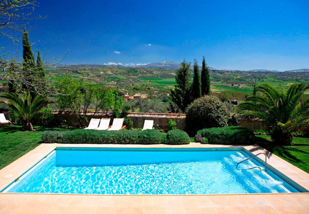 Immagine di una piscina mediterranea rettangolare con pavimentazioni in pietra naturale
