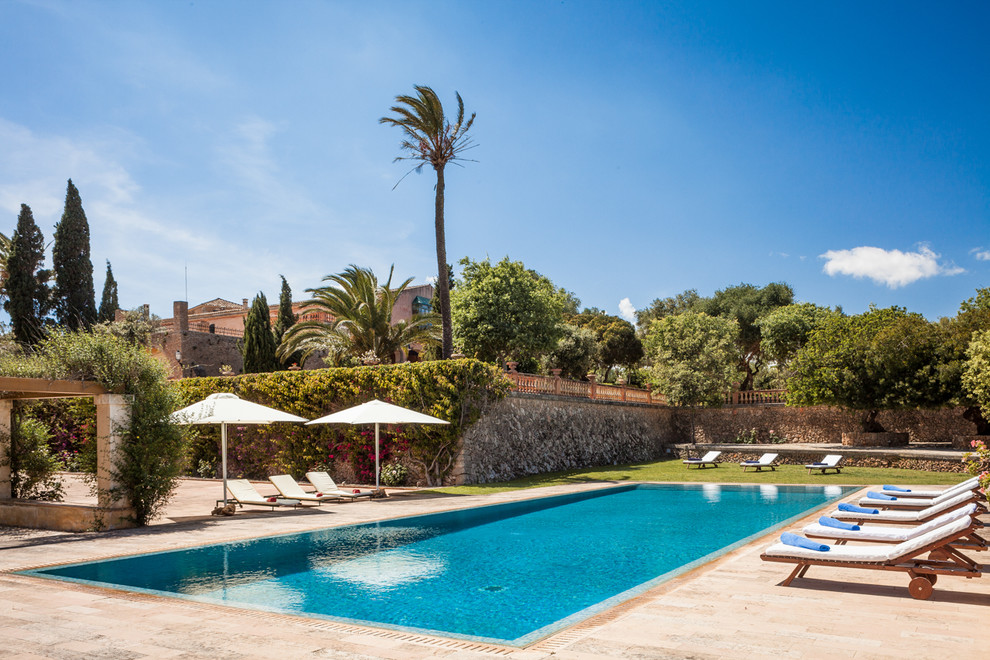 Foto de casa de la piscina y piscina alargada mediterránea grande rectangular en patio trasero con adoquines de piedra natural