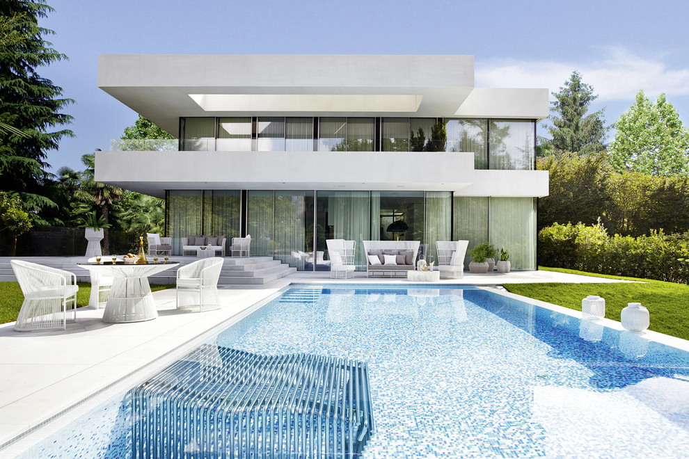 Immagine di una piscina contemporanea rettangolare dietro casa con piastrelle