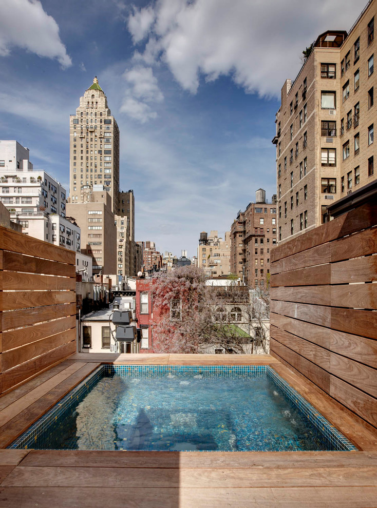 Exemple d'une piscine chic rectangle avec une terrasse en bois.