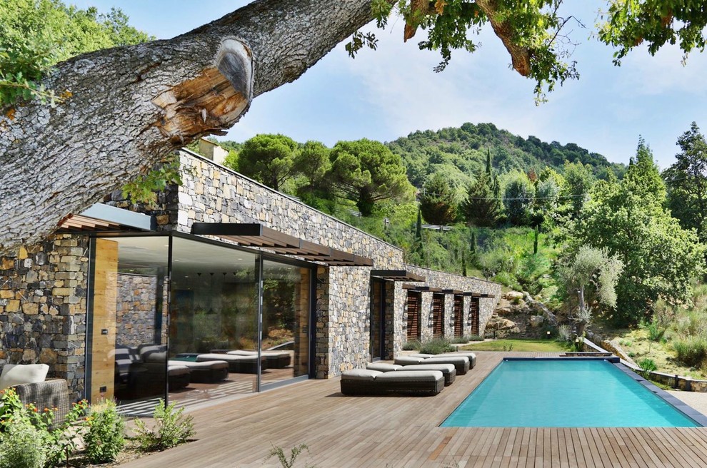 Cette photo montre une piscine arrière tendance rectangle avec une terrasse en bois.