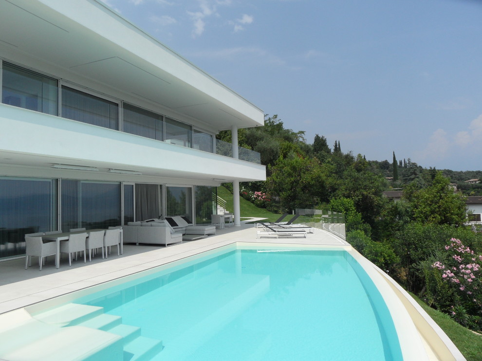 Design ideas for a modern custom shaped infinity swimming pool in Milan.