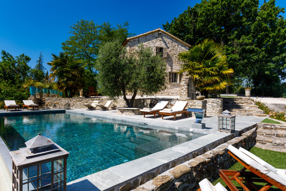 Modelo de piscina mediterránea rectangular en patio trasero