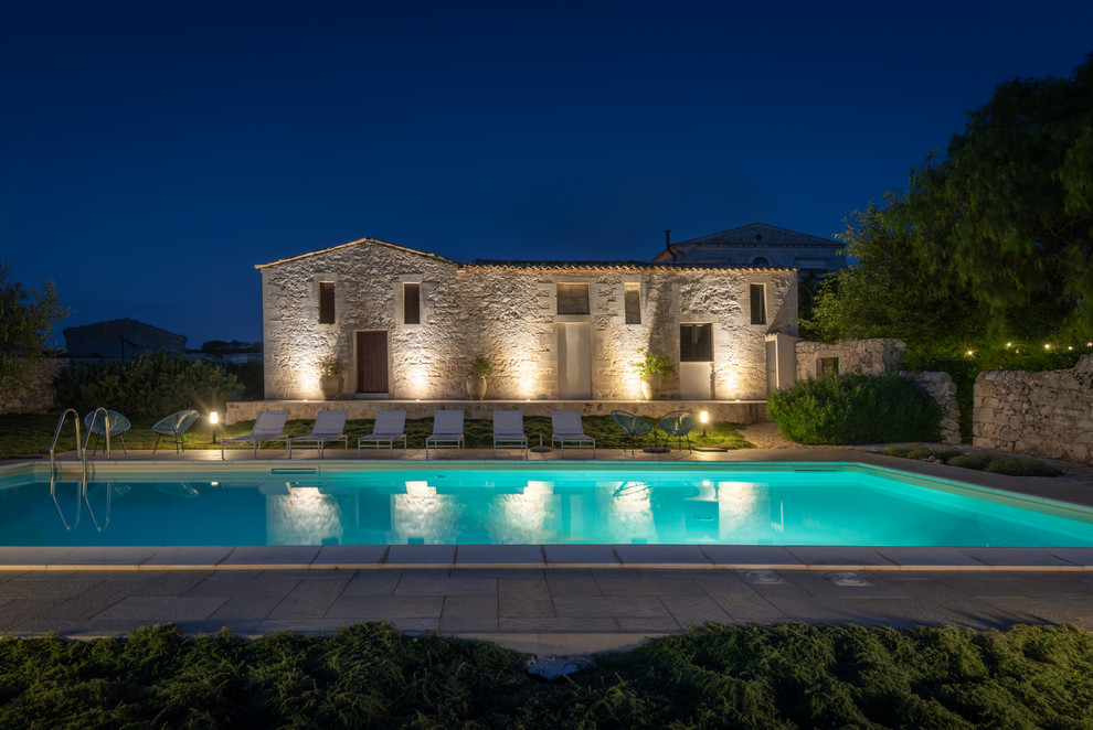Esempio di una grande piscina monocorsia mediterranea rettangolare dietro casa con pavimentazioni in cemento