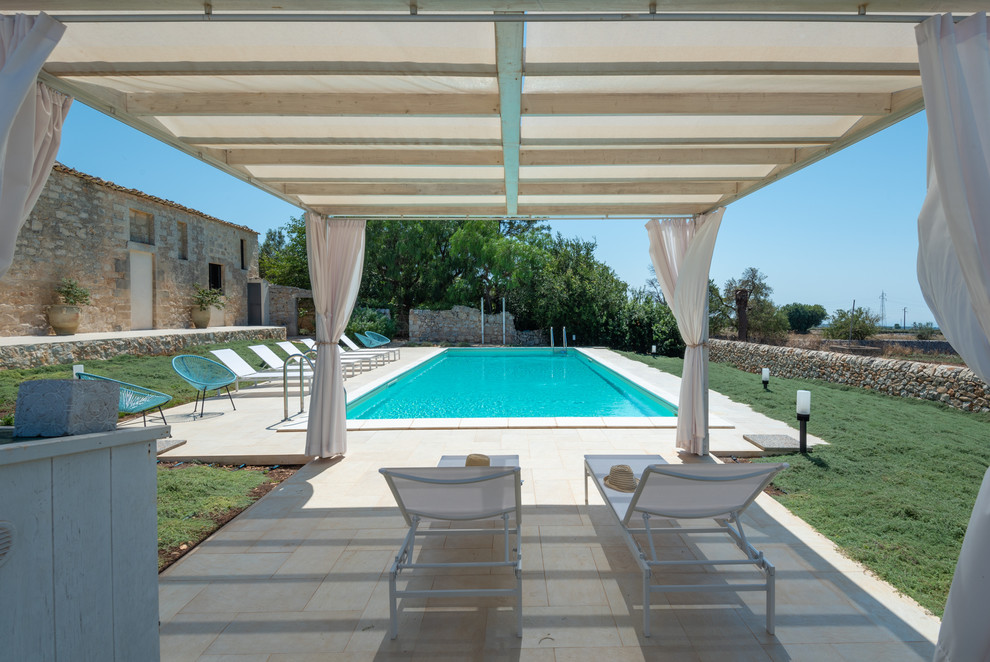 Modelo de piscina mediterránea grande rectangular en patio trasero