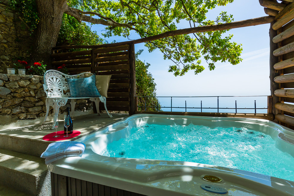 Idee per una piscina fuori terra mediterranea rettangolare dietro casa con una vasca idromassaggio e piastrelle